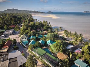 Un pueblo costero con casas, una playa y una montaña al fondo.