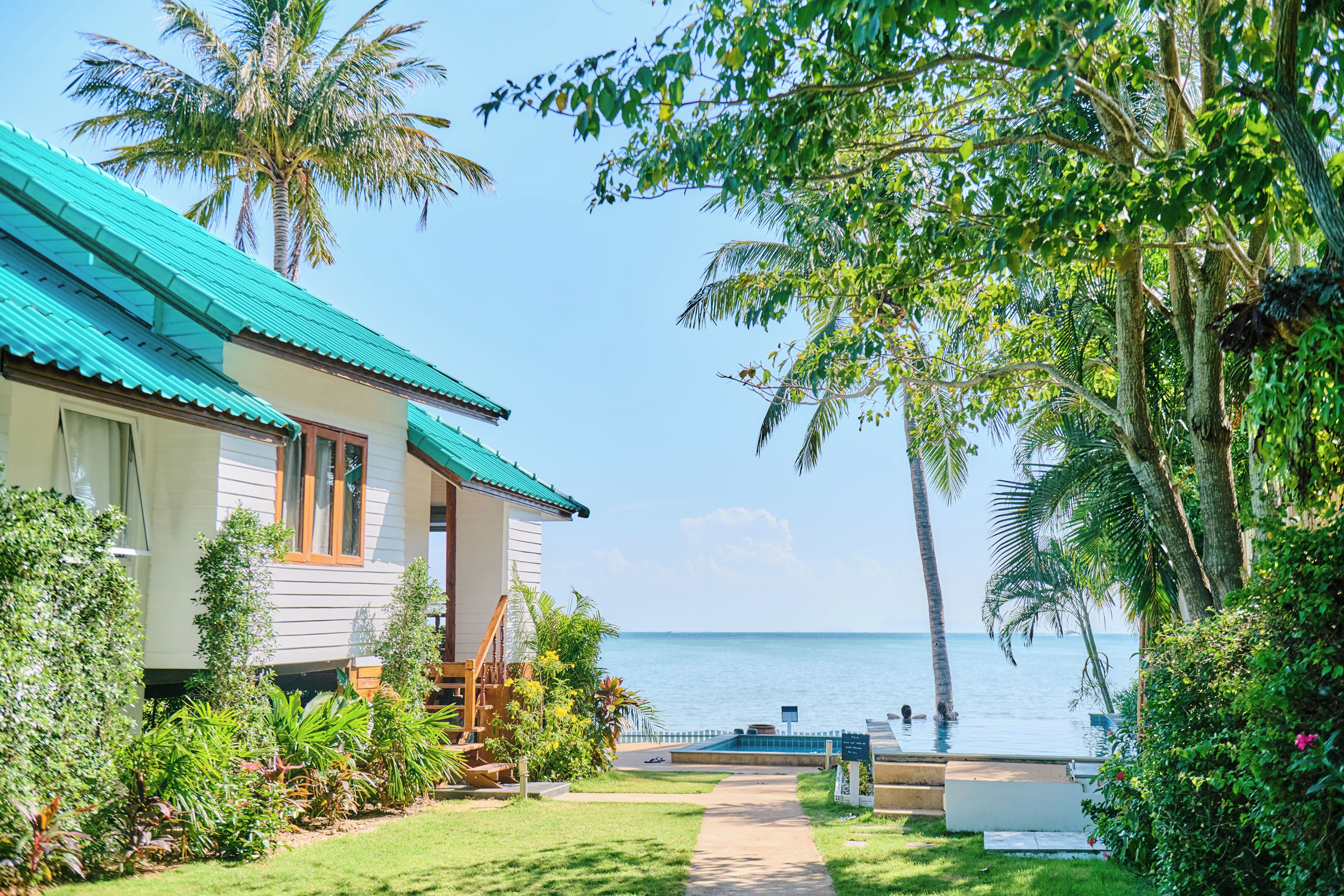 Ein Strandgrundstück mit Haus, Swimmingpool und freiem Blick auf den Ozean.