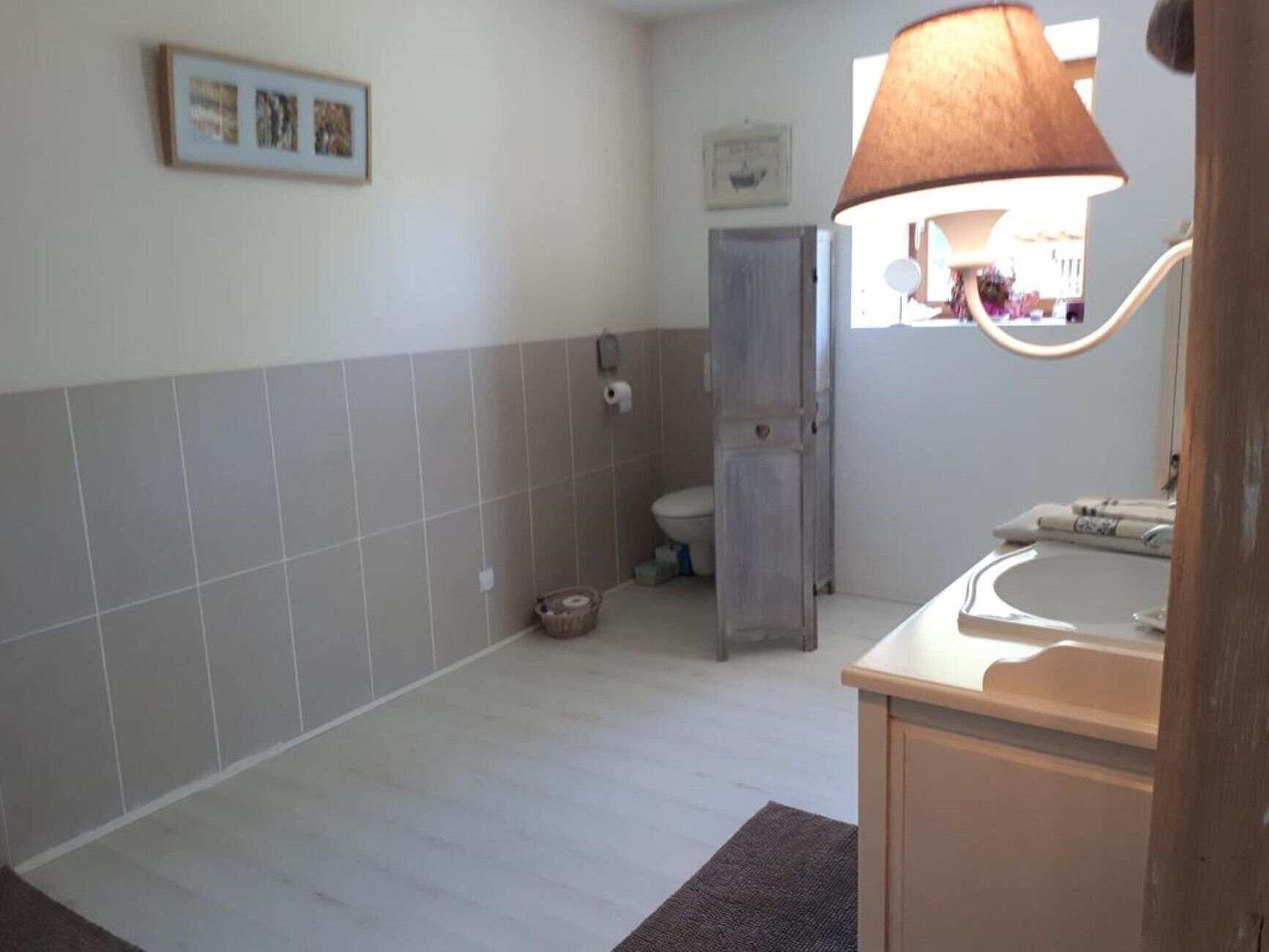 Een badkamer met een toilet, wastafel en handdoekhouder.