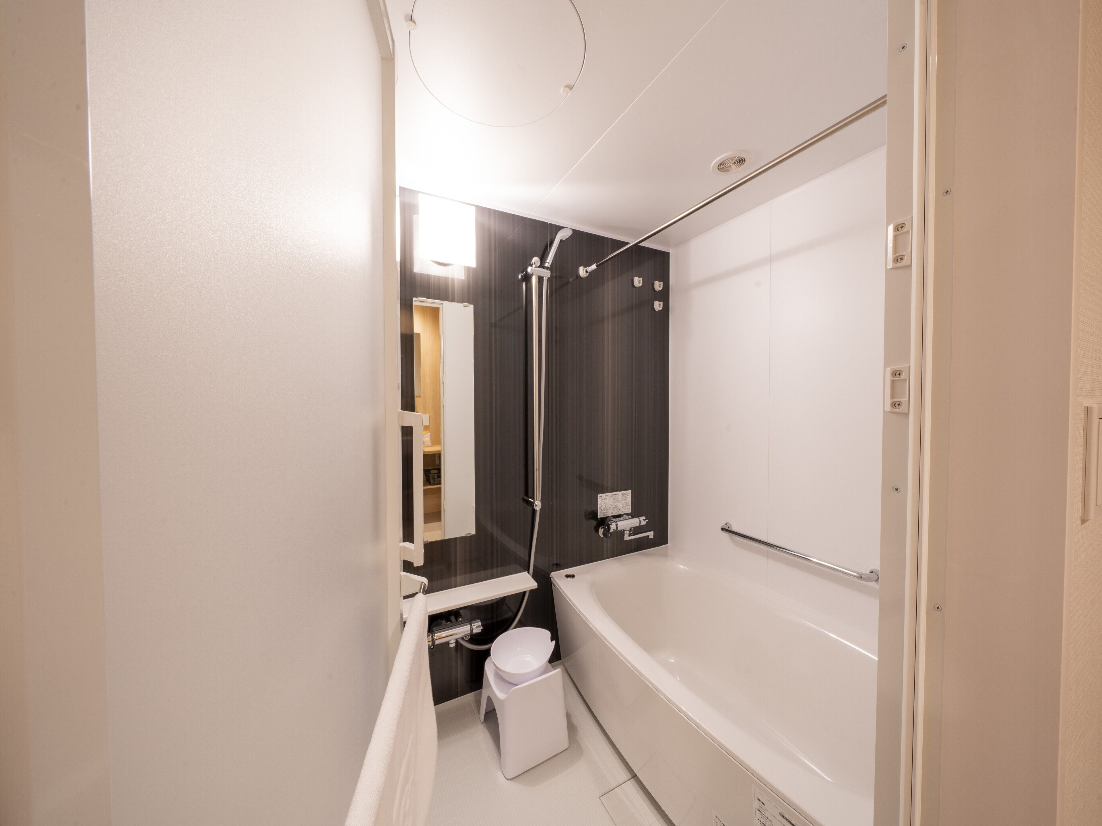 A modern bathroom with a bathtub, toilet, and shower area.