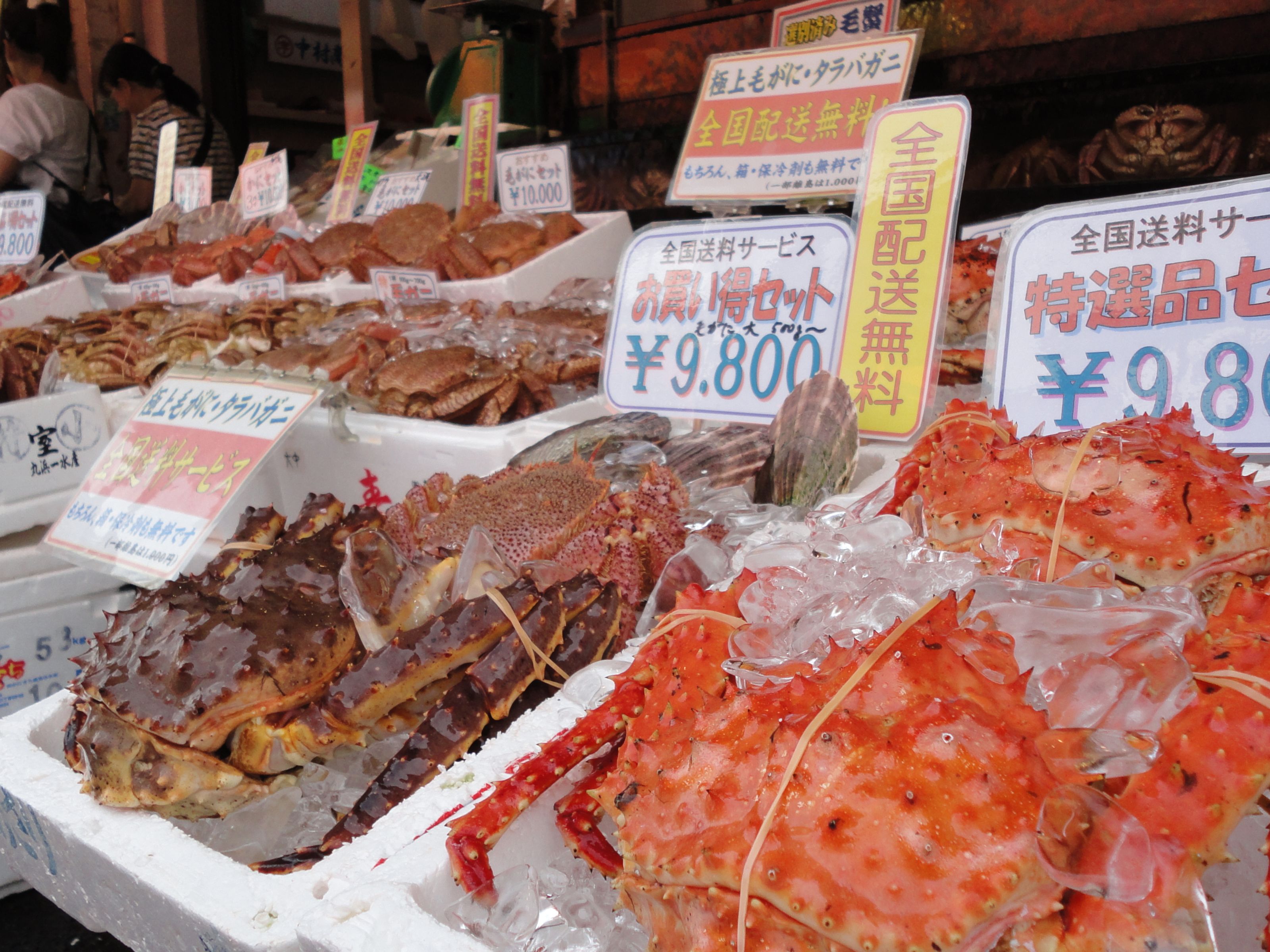 Mercado de mariscos con diversos tipos de pescado y mariscos expuestos sobre hielo.