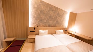 Una habitación de hotel moderna con una cama grande, cabecero de madera y un detalle decorativo en la pared.
