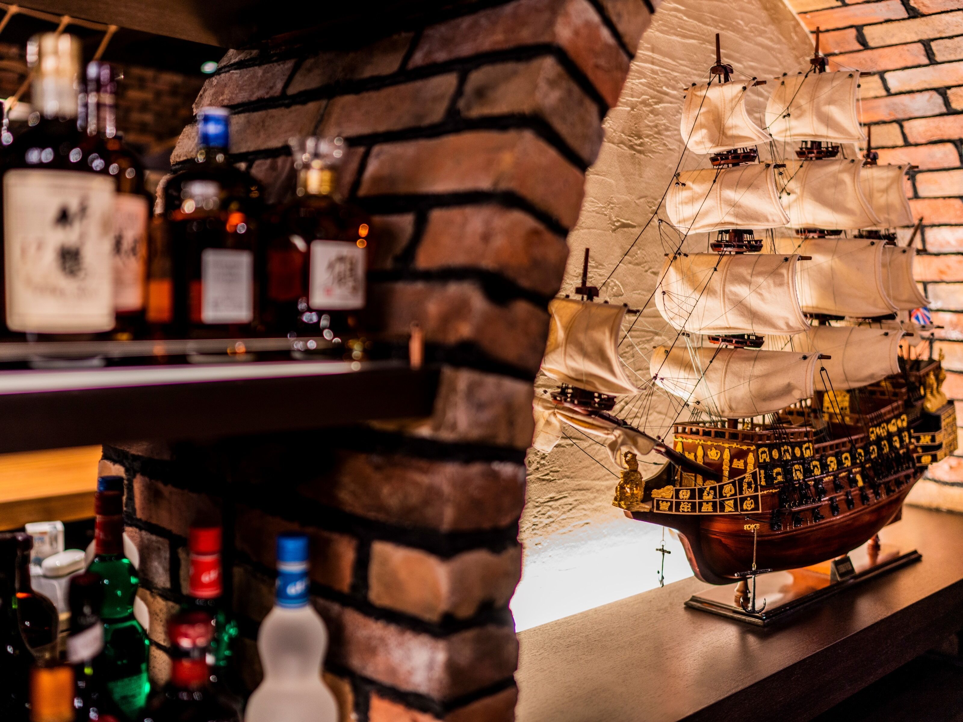 A bar area with a ship model and various bottles.