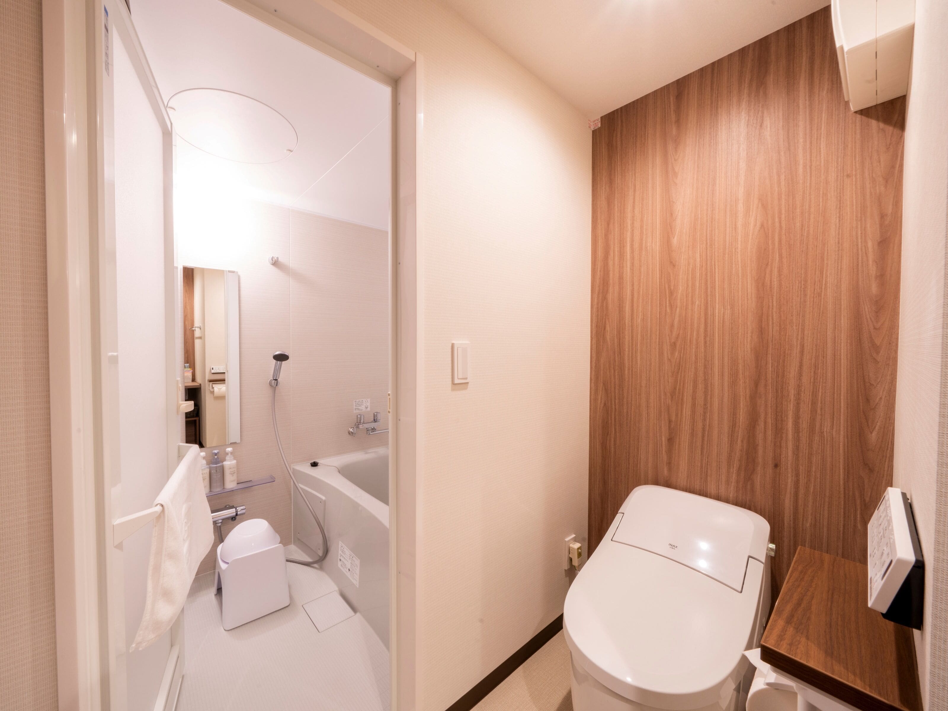 A modern bathroom with a shower, toilet, and sink.