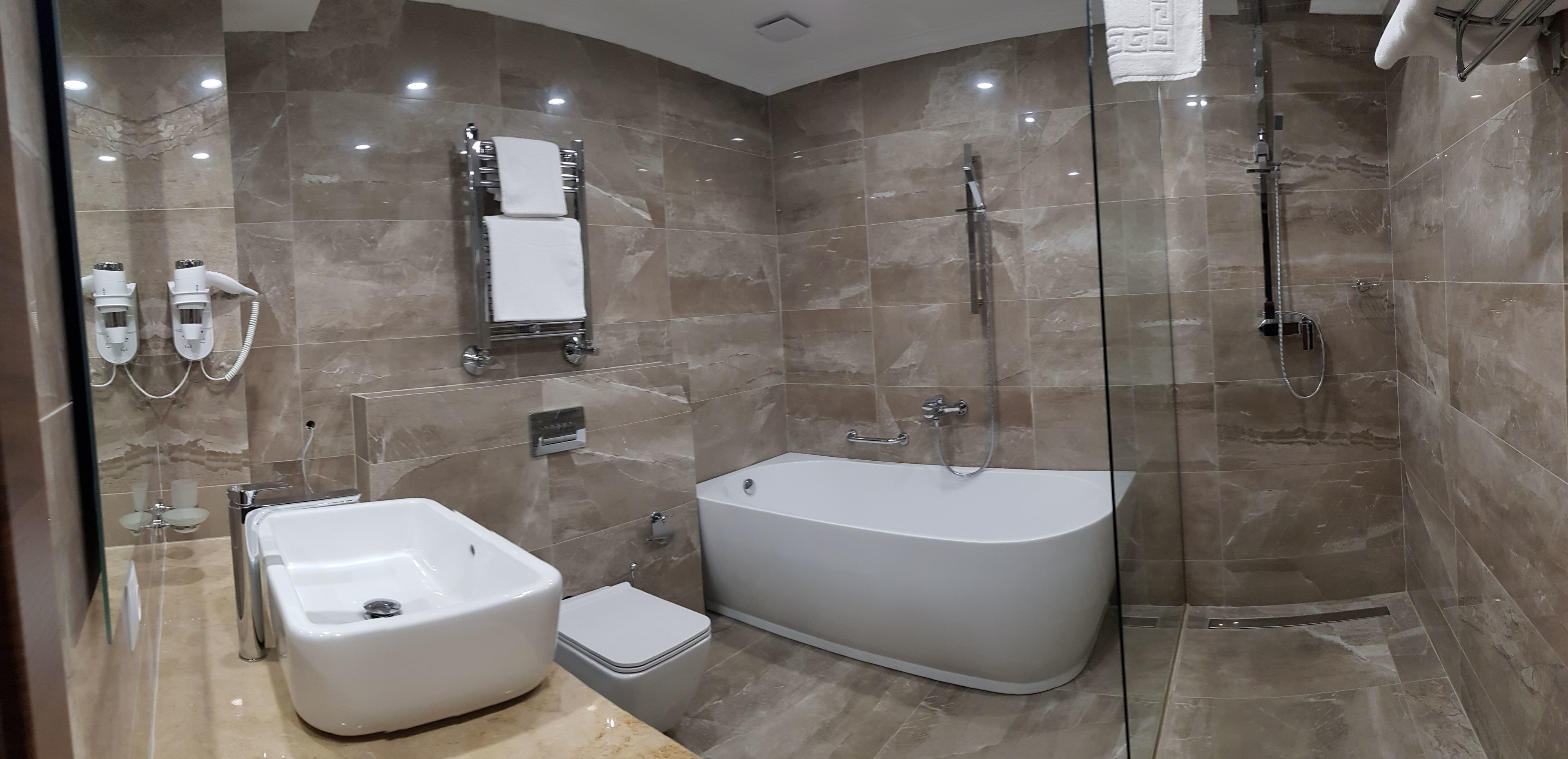 A modern bathroom with a freestanding bathtub, a separate shower area, and a toilet.