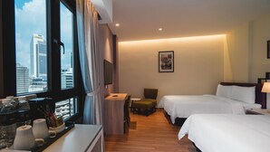A hotel room with two beds, a desk with a chair, a small table, and a window with curtains. - M Palace Hotel (Kuala Lumpur)