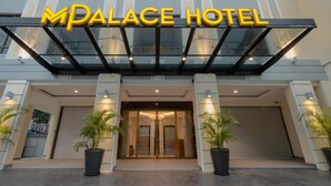 The exterior of the MPALACE HOTEL with a modern design, featuring a glass entrance and potted plants. - M Palace Hotel (Kuala Lumpur)