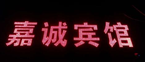 Caracteres chinos iluminados sobre un fondo oscuro.