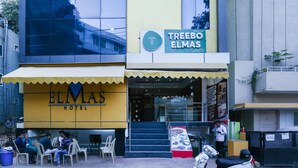 A hotel named 'ELMAS' with a yellow facade and a sign for 'TREEBO ELMAS'. - Itsy Hotels Elmas Golden Key (Bengaluru)