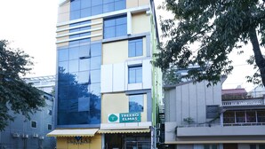 A multi-story hotel with a modern facade, large windows, and a visible sign for 'Treebo Elmas Hotel'. - Itsy Hotels Elmas Golden Key (Bengaluru)