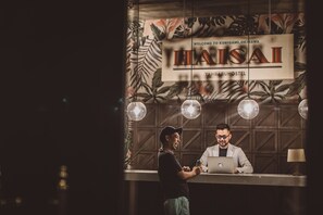 A reception desk with a sign reading "Welcome to Kunigami, Okinawa" and "Yamaburu Hostel". - Yanbaru Hostel (Kunigami)