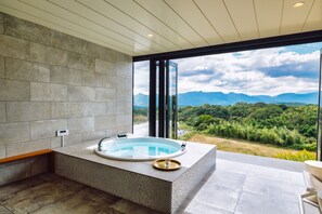 A modern bathroom with a freestanding bathtub, a large window, and a view of mountains. - COMOREBI -yufuin onsen gramping- (Yufu)