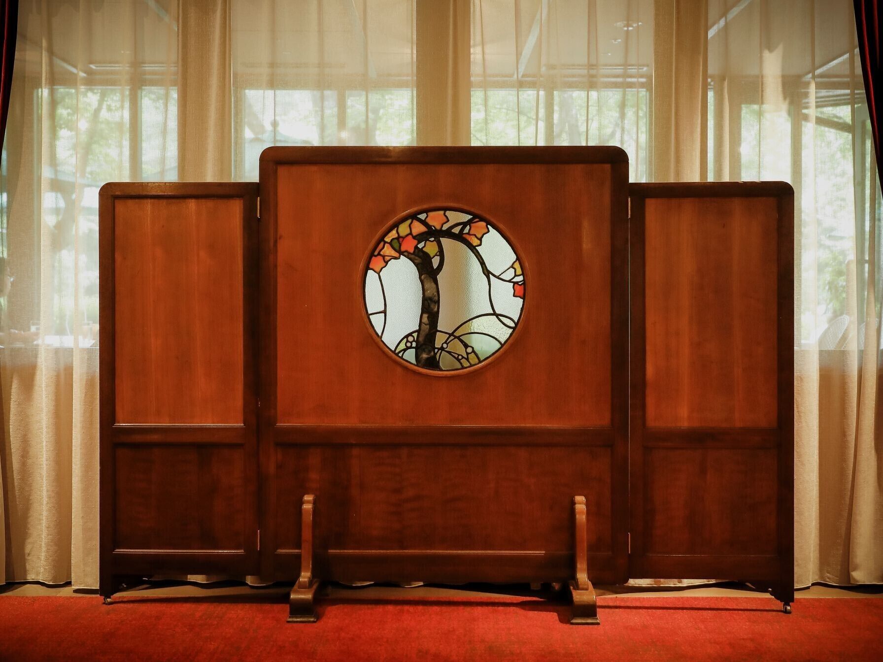 Una habitación con un mueble de madera grande que incluye un vitral.