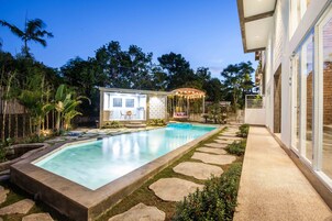 Una piscina al aire libre, sillones reclinables de piscina