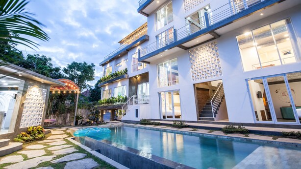 A modern multi-story building with a swimming pool, outdoor staircase, and balconies. - Ohana Pererenan (Pererenan)
