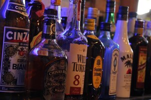 A variety of liquor bottles on a shelf.
