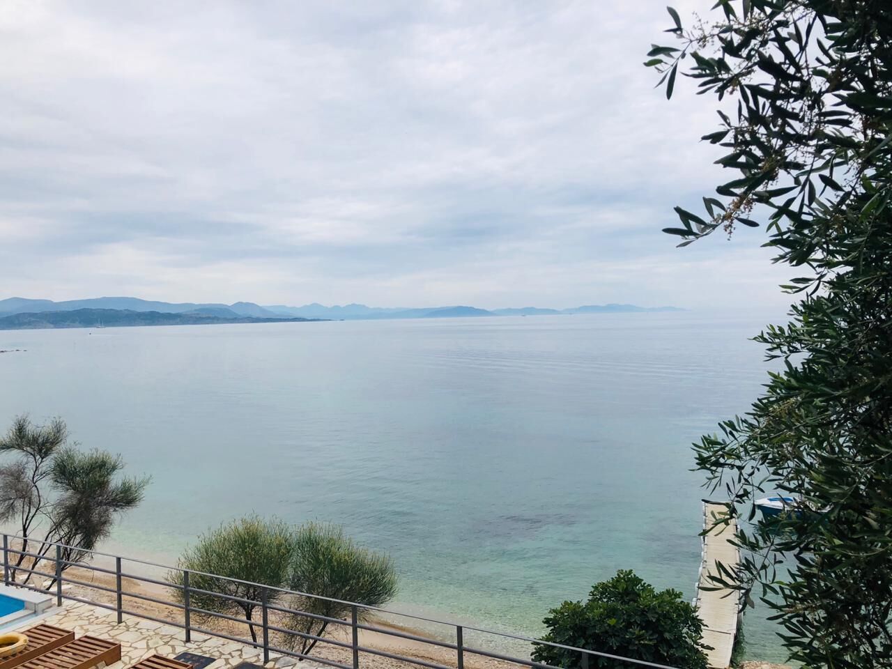 A coastal view with a clear sky, a sandy beach, and a calm sea.