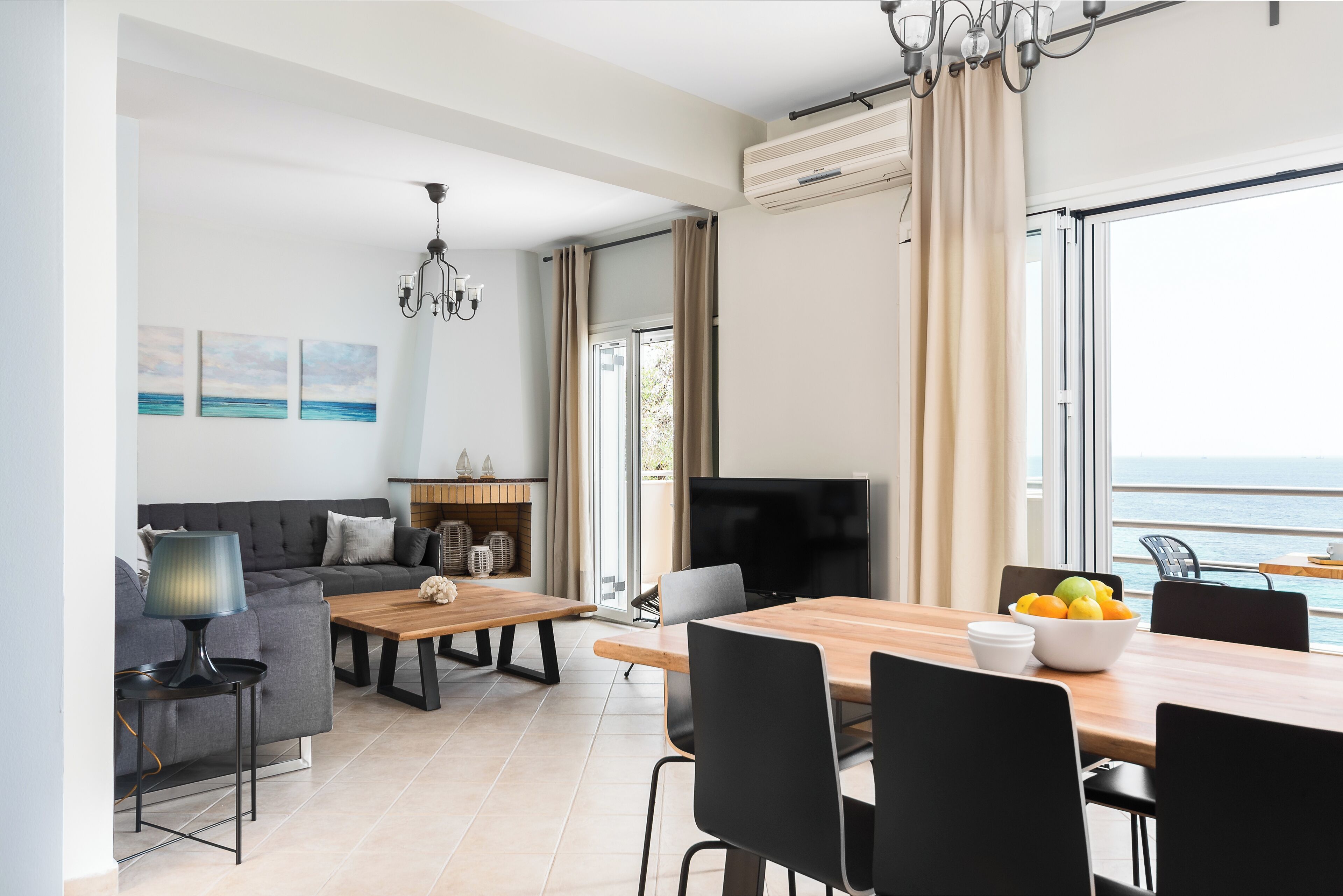 Un salon moderne comprenant un canapé, une table basse, un téléviseur et un coin repas.