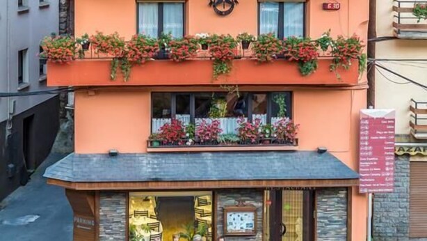 A building with a sign reading "HOSTAL TALABART" and balconies with flowers. - Hotel Talabart (Les)