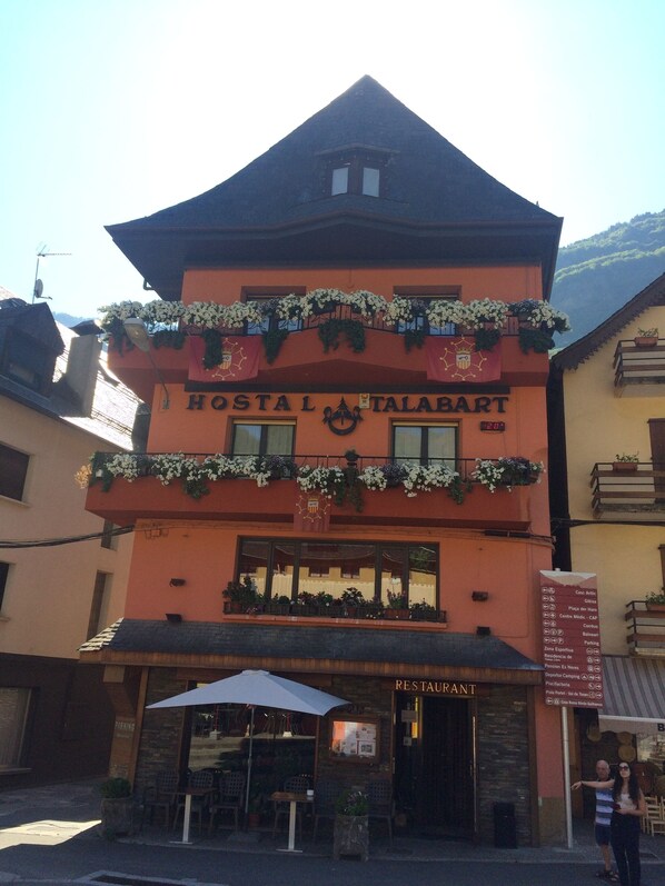 Un edificio con un letrero que dice "HOTEL TALABART" y un letrero de restaurante debajo.