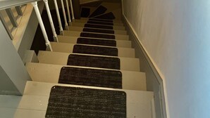 A staircase with white railings and black carpeted steps. - 2BR-Free Parking, 5Min to Providence, 10Min to Ma-I-95 (Pawtucket)