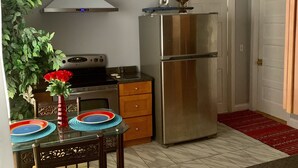 A compact kitchen with a stainless steel refrigerator, a gas stove, and a ceiling fan. - 2BR-Free Parking, 5Min to Providence, 10Min to Ma-I-95 (Pawtucket)