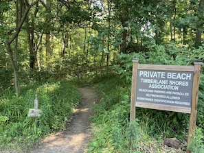 Access the beach via a scenic dirt path surrounded by lush greenery.
