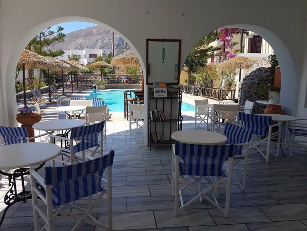 Una piscina al aire libre de temporada, sombrillas