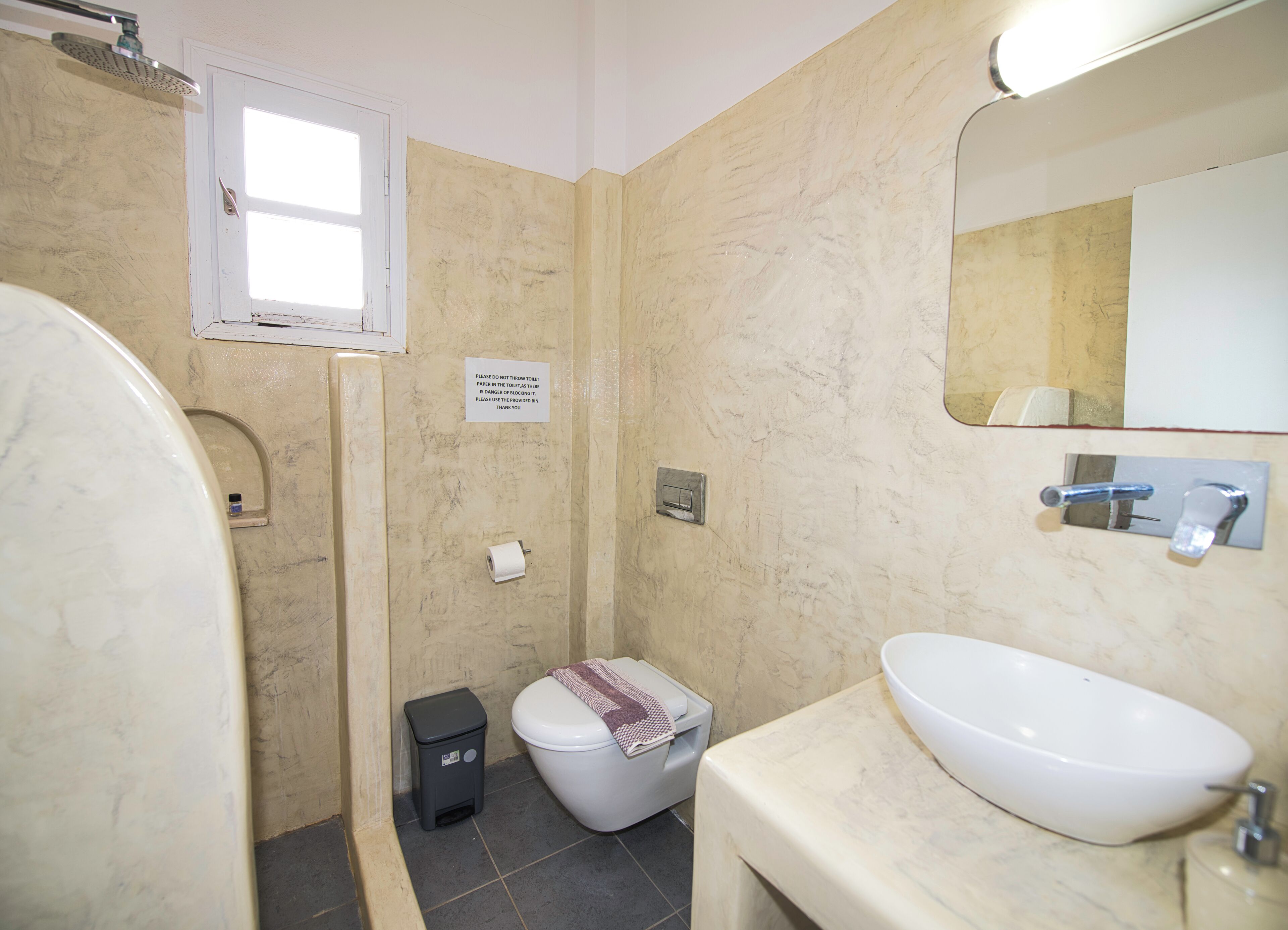 A bathroom with a shower, toilet, and sink.