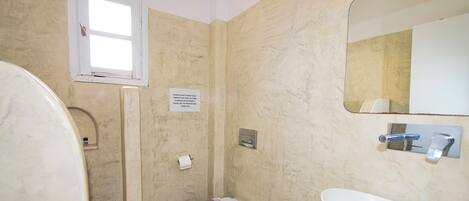 A bathroom with a shower, toilet, and sink.