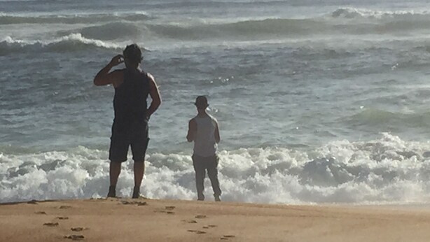 A beach with footprints leading to the water. - Glenaire apartments at Pontifex (Strahan)