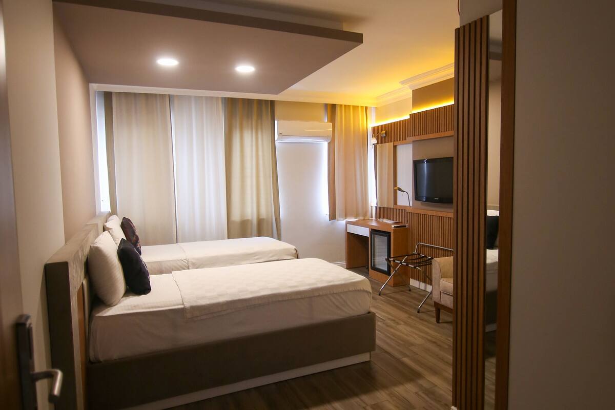Una habitación de hotel con una cama grande, un escritorio, una silla y un televisor.