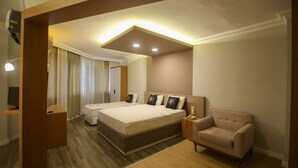 A hotel room with two beds, a sofa, a desk, and a mirror. - Cevik Palace Otel (Antalya)