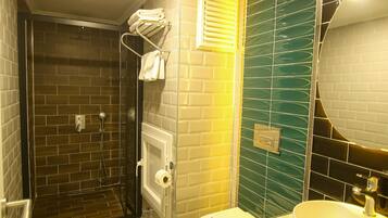 Ein Badezimmer mit Duschkabine, Toilette in Weiß und Waschbecken mit Spiegel.