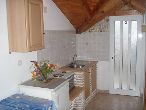 A compact kitchen with a built-in stove, a sink, and a small countertop.