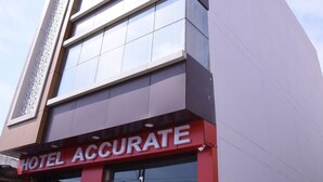 A hotel with a modern facade, large windows, and a prominent red sign reading "HOTEL ACCURATE". - HBC Hotel Accurate (Rishikesh)
