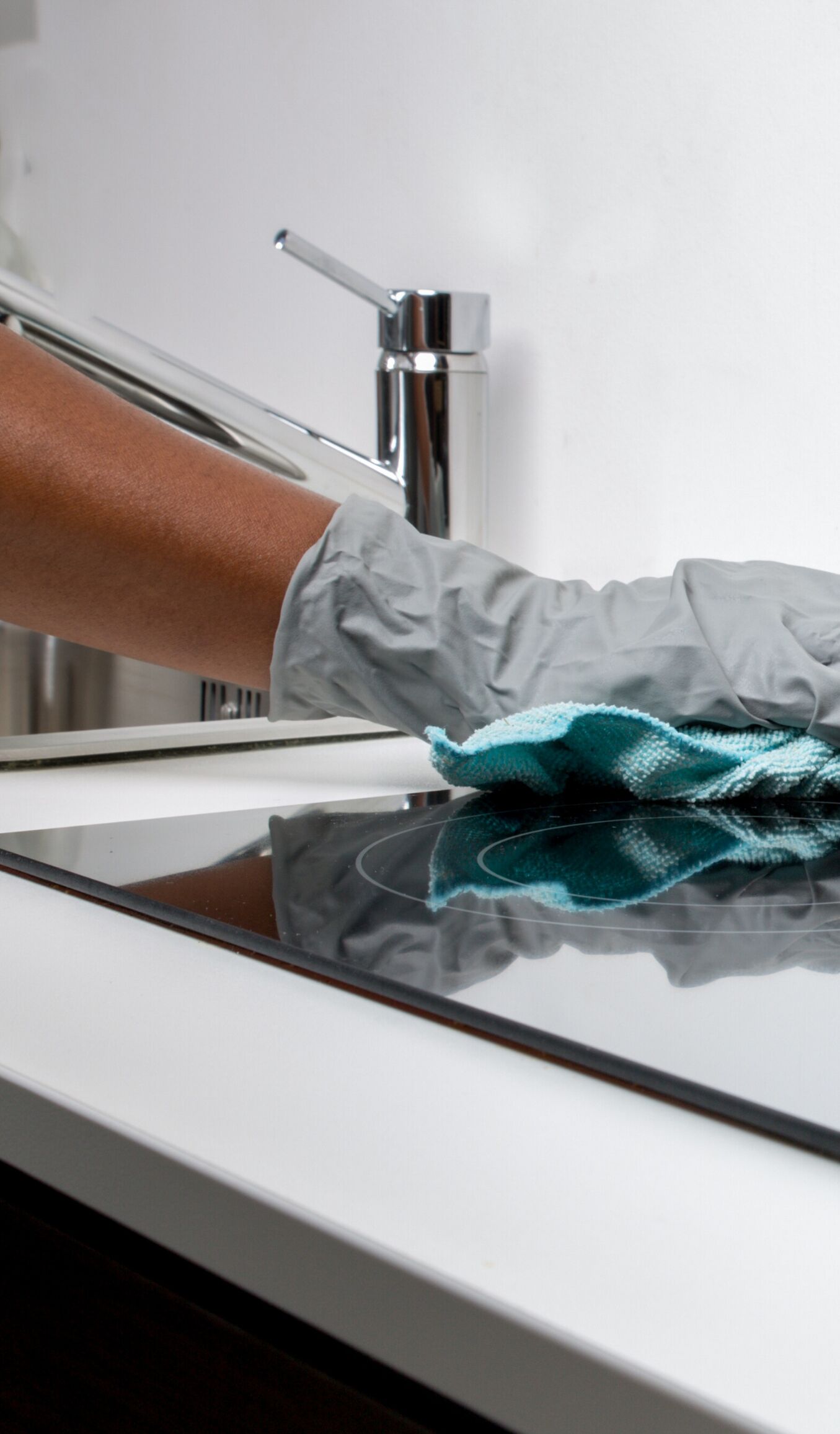 A hand cleaning a reflective surface with a cloth.