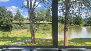 Uma banheira de hidromassagem com vista para um lago e árvores.