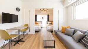 A modern hotel room with a dining area, a sofa, and two beds. - SG Residence Inn Hakata (Fukuoka)