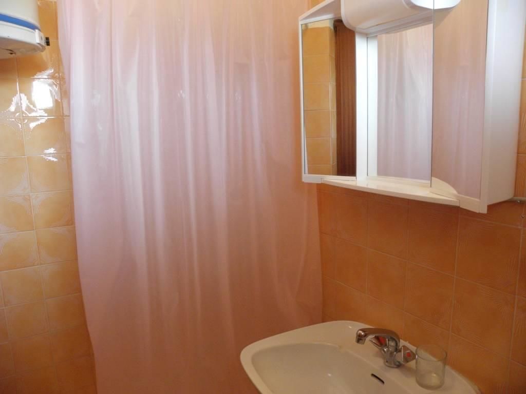A bathroom with a sink, mirror, and shower curtain.