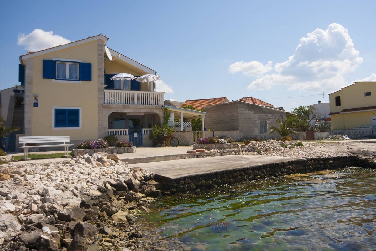 A two-story building with a balcony and outdoor seating.