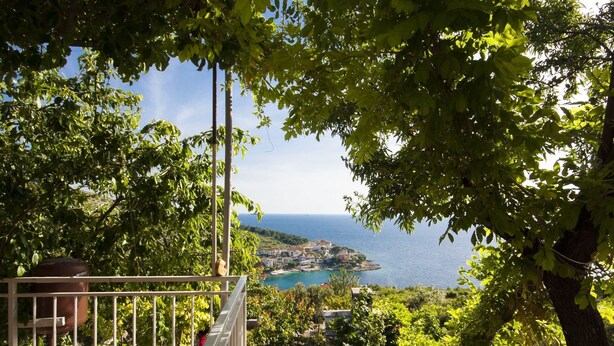 A balcony with a view of a coastal town and the sea. - Apartments Nikica Primosten (Primosten)