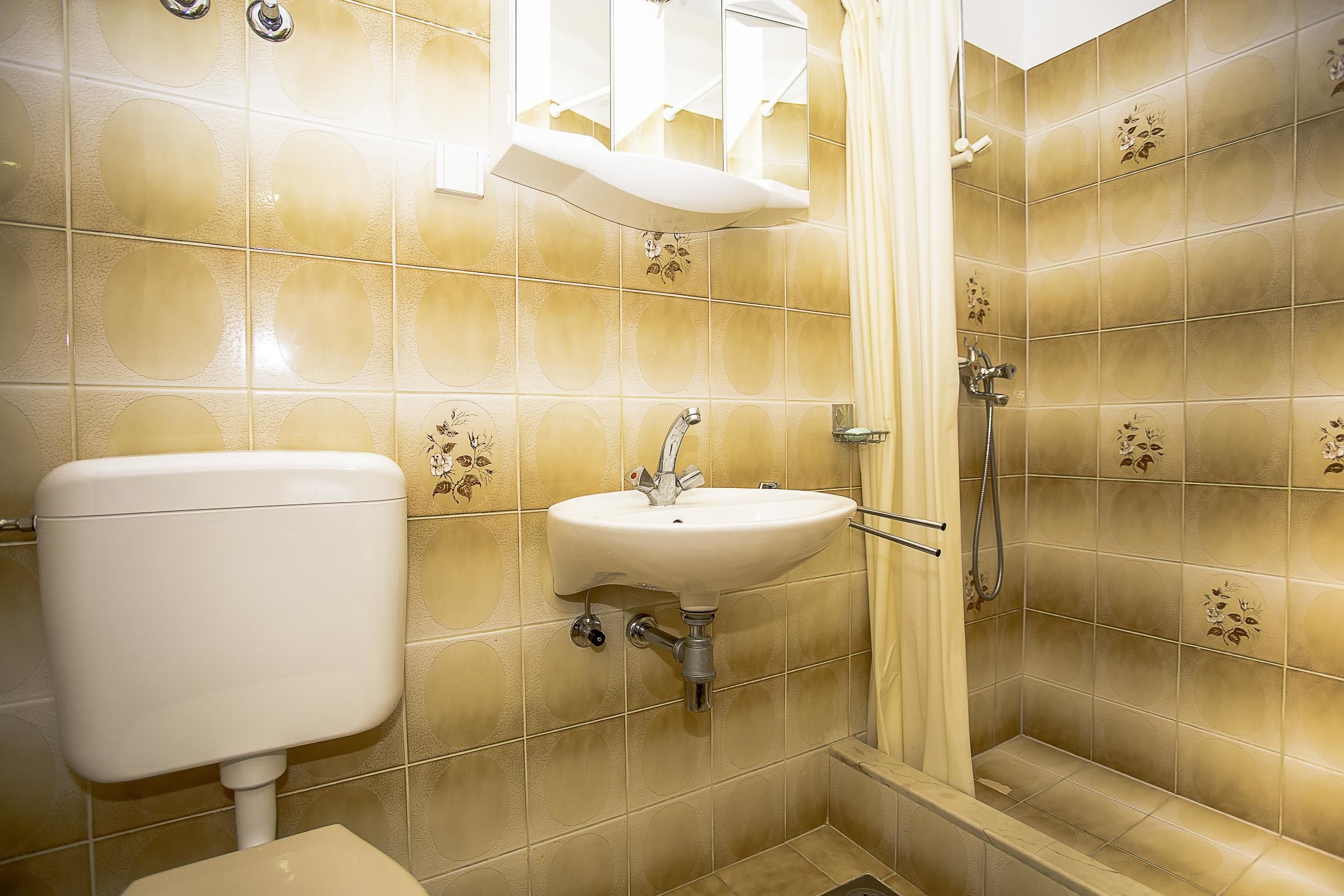 A bathroom with a toilet, sink, and shower.