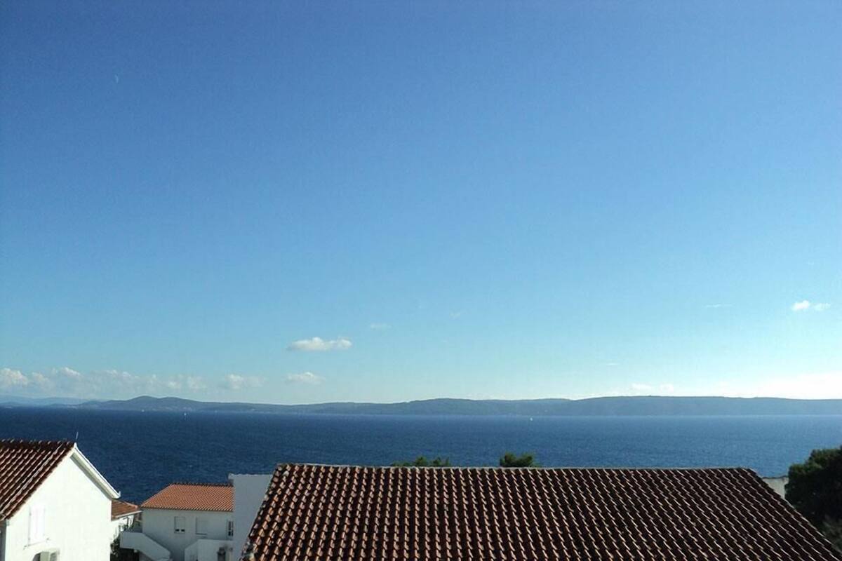 A coastal view with terracotta rooftops and a clear blue sky.