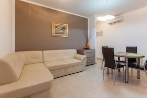 Apartment, Mehrere Betten | Wohnzimmer | Fernseher