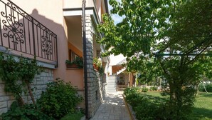 Un vialetto in pietra conduce a un edificio con un balcone e una scala.