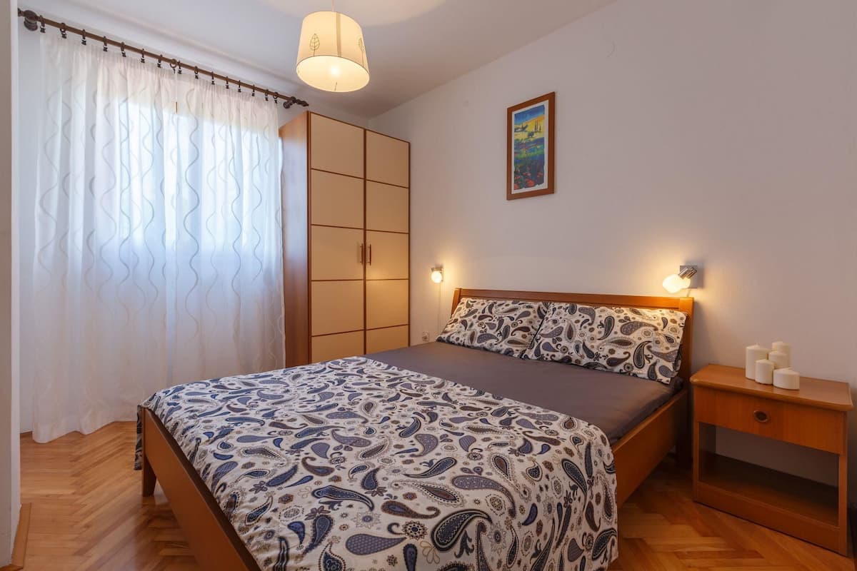 Ein Schlafzimmer mit Bett, Nachttisch, Kleiderschrank und einem Bild an der Wand.