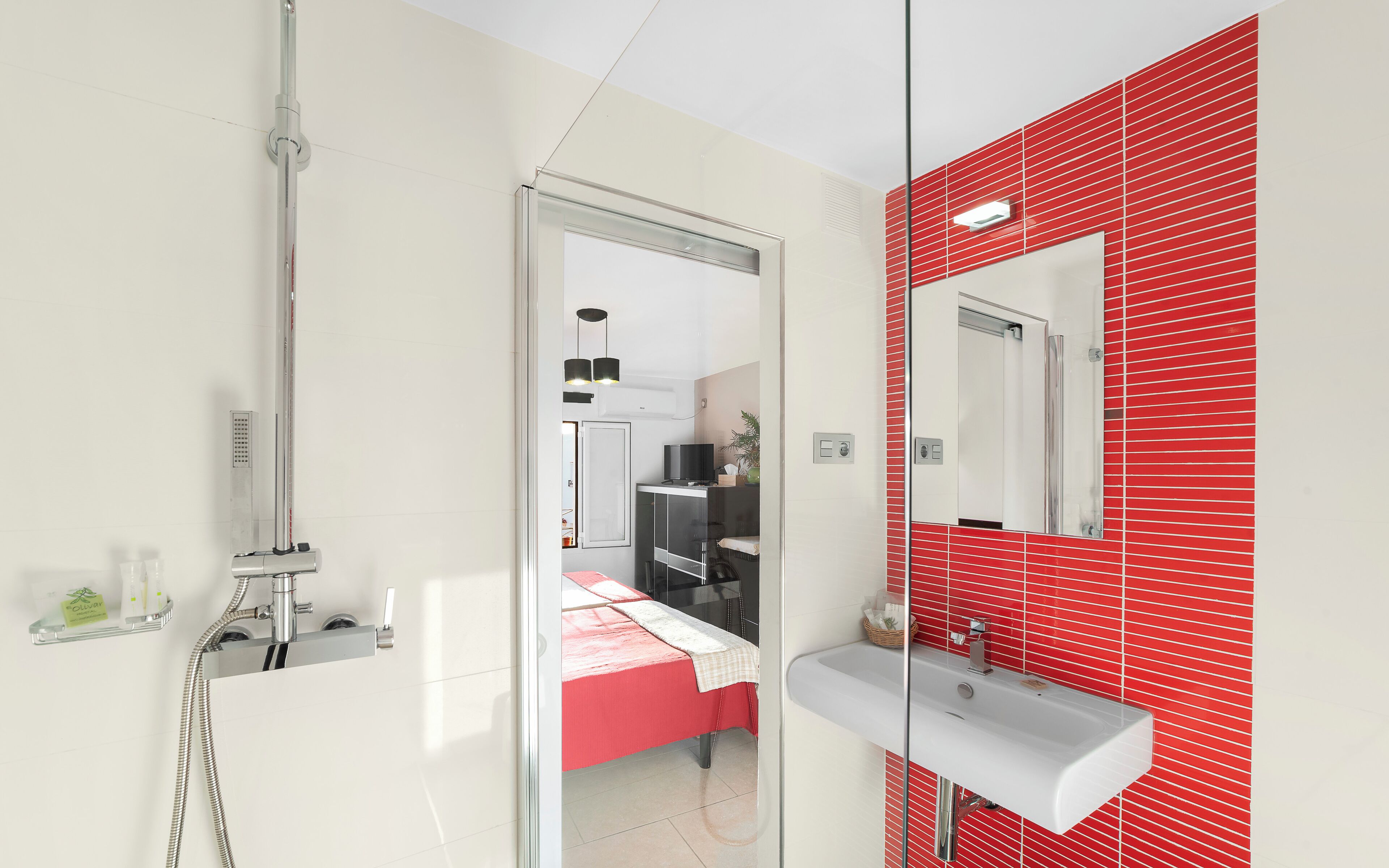 A modern bathroom with a shower, a sink, and a mirror.