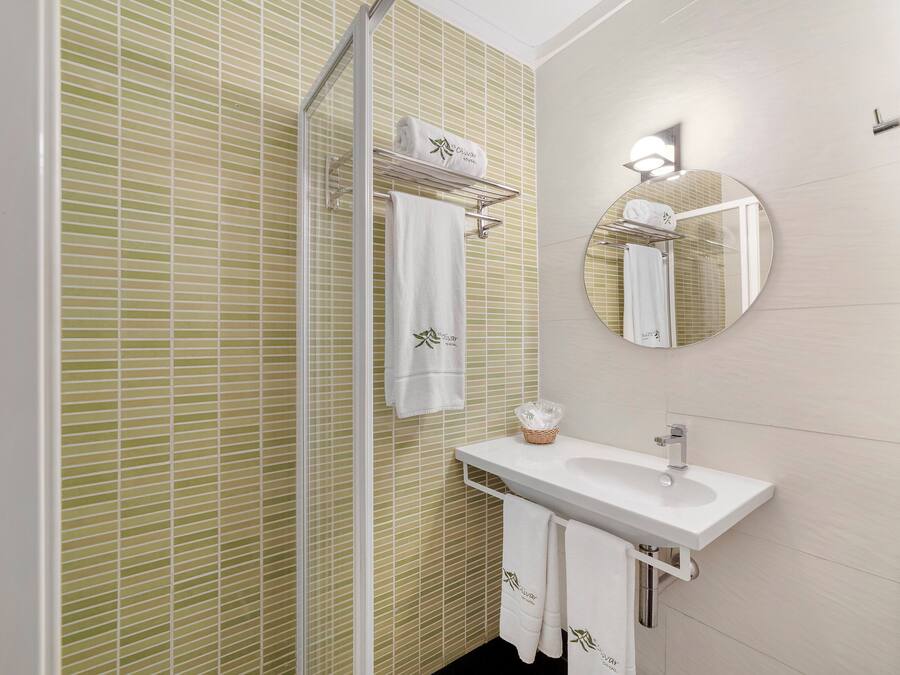 A bathroom with a white sink, a mirror, and a towel rack.