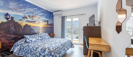 Un dormitorio con cama, escritorio y vistas al exterior.